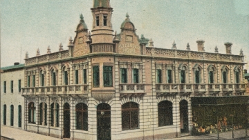 A picture of a two storey pub, against a soft blue sky