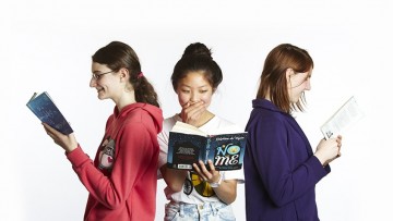 Photograph of three teenagers reading books