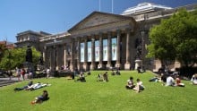 Colour photo of the State Library Victoria facade and lawn with people relaxing by Andrew Lloyd