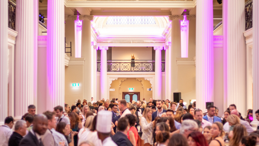 Busy room with tall white columns