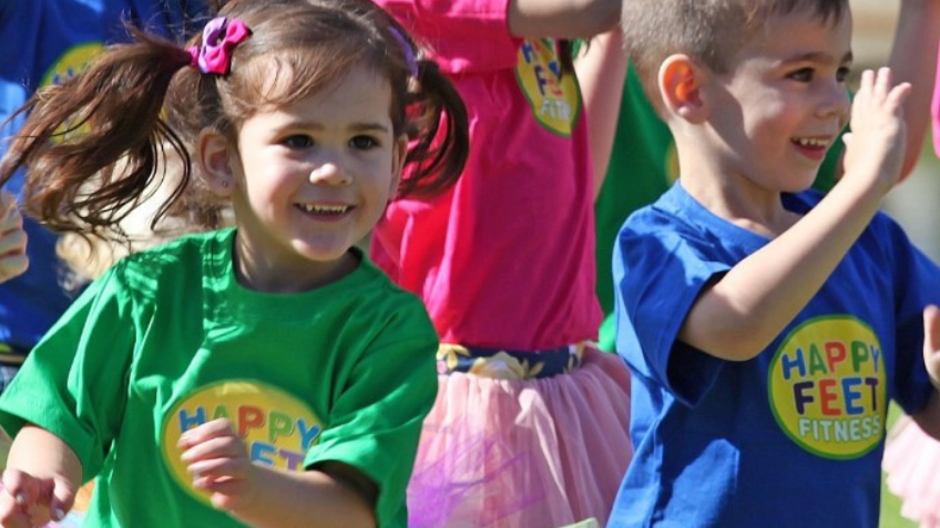 Kids laughing and dancing with Happy Feet Fitness instructors