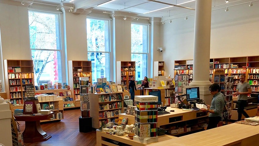 Readings bookshop in Russell Street Welcome Zone with large windows, wooden shelving and books