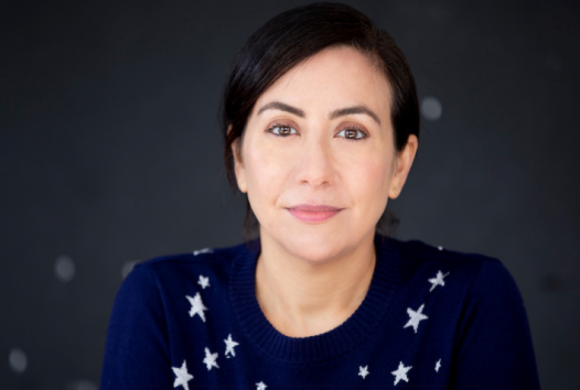 Woman smiling at the camera with dark background