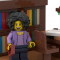 A LEGO set of a librarian standing in front of a book shelf